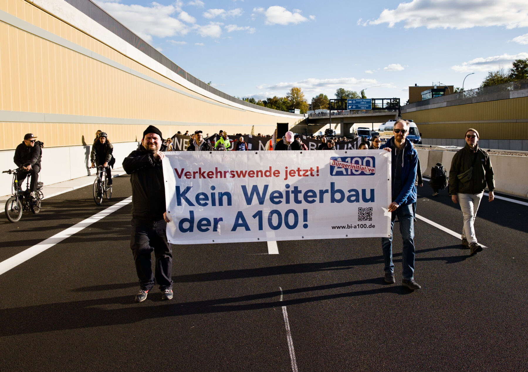 Banner der Bürger*innenInitiative A100 auf der Autobahn bei einer Demo