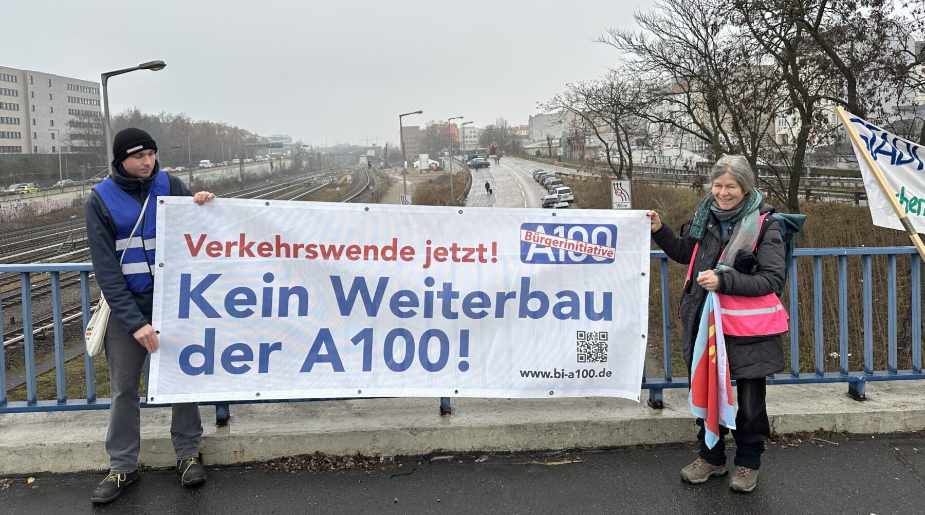 Aktive der Bürger*innenInitiative A100 mit Banner auf der Brücke über der Baustelle der Westendbrücke